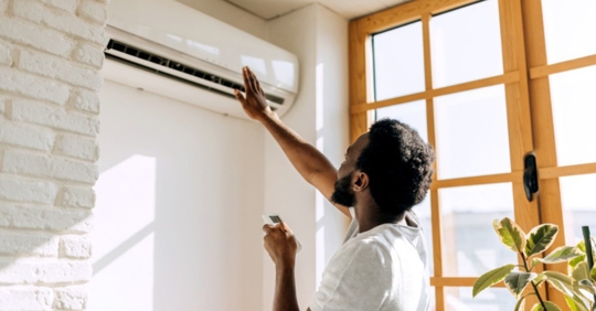 homeowner adjusting a ductless mini-split